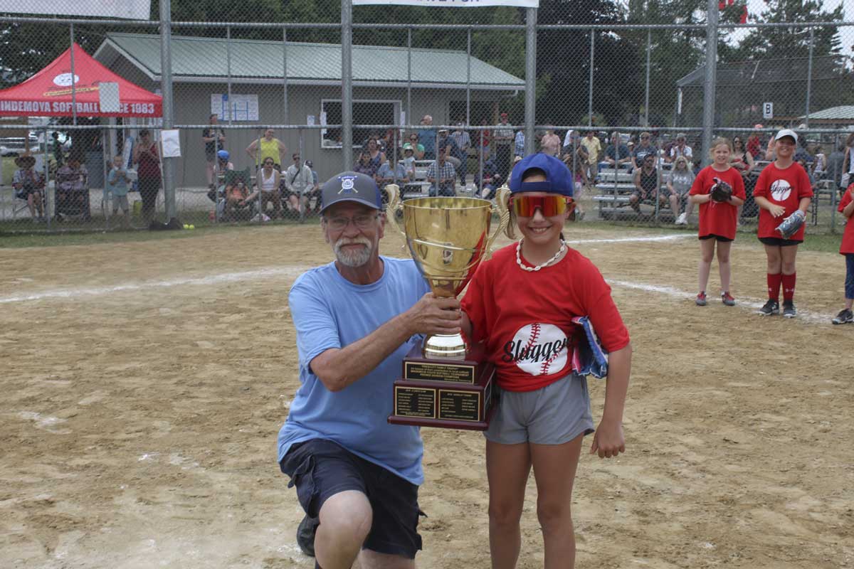 Delroy Prescott, left, presents the Prescott A division (8-10 year-old) championship trophy to a member of the Espanola Sluggers. 